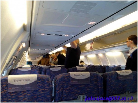 vnitřek letadla pohled na nastupující cestující 